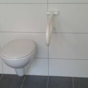 Stützklappgriffe für behindertengerechtes Bad von der Krankenkasse Das Foto zeigt ein WC mit Stützklappgriffen.