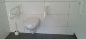 Das Foto zeigt ein WC mit Stützklappgriffen.