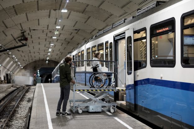 Rollstuhlfahrerin auf einer mobilen Hebebühne.
